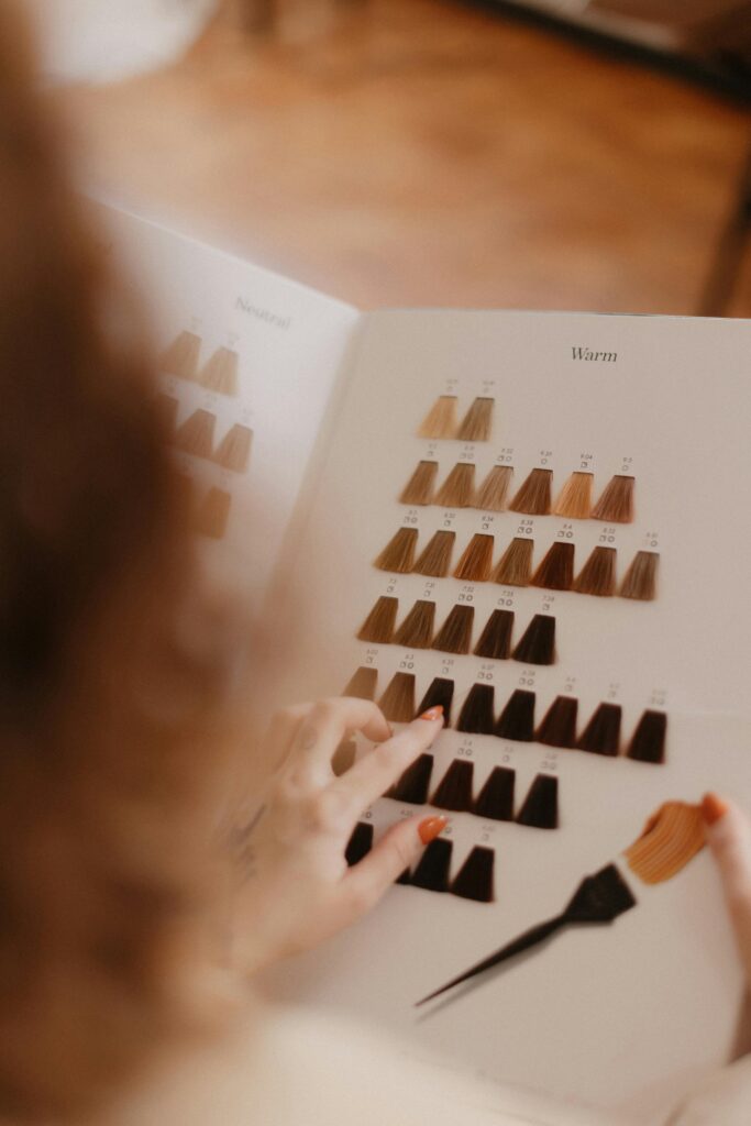 Person selecting hair color from a sample palette in a salon setting.
